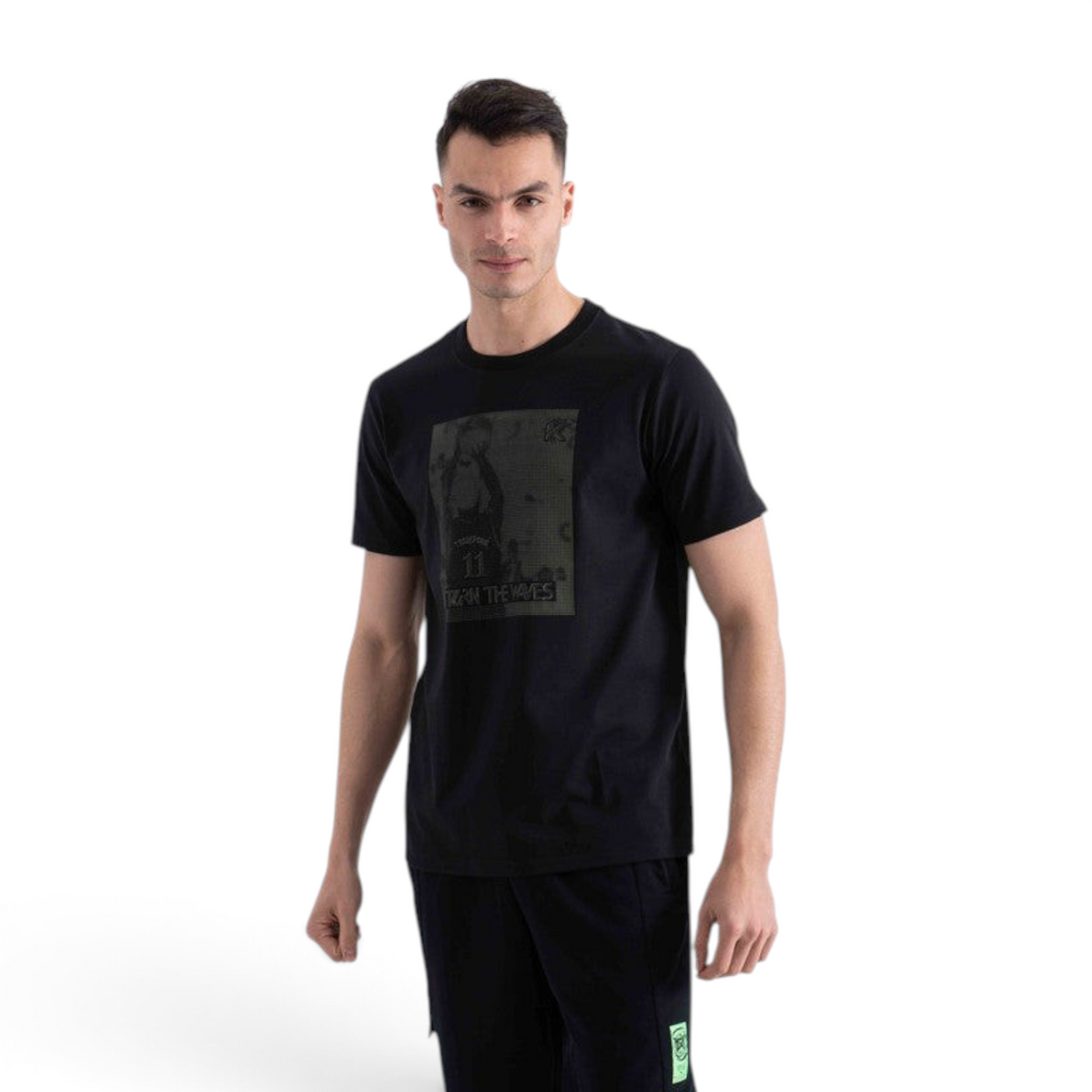 A man wearing a black FRG short-sleeve t-shirt with a graphic print on the chest, isolated on a white background.
