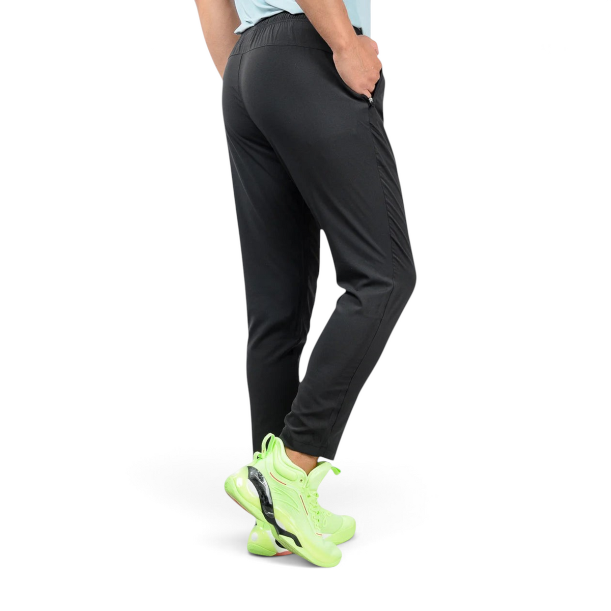 FRG black ankle pants with a slim fit, worn by a model with bright neon green athletic sneakers