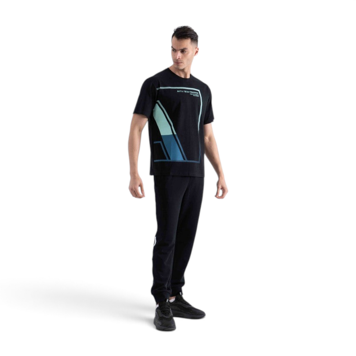 A man wearing a black FRG SS TEE with a geometric blue and teal graphic print on the front, paired with black pants.
