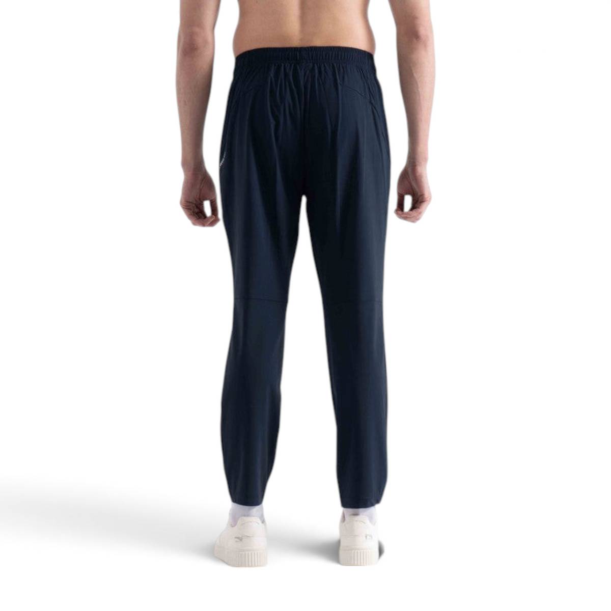 Back view of a man wearing FRG navy blue knit track pants with an elastic waistband, isolated on white background.
