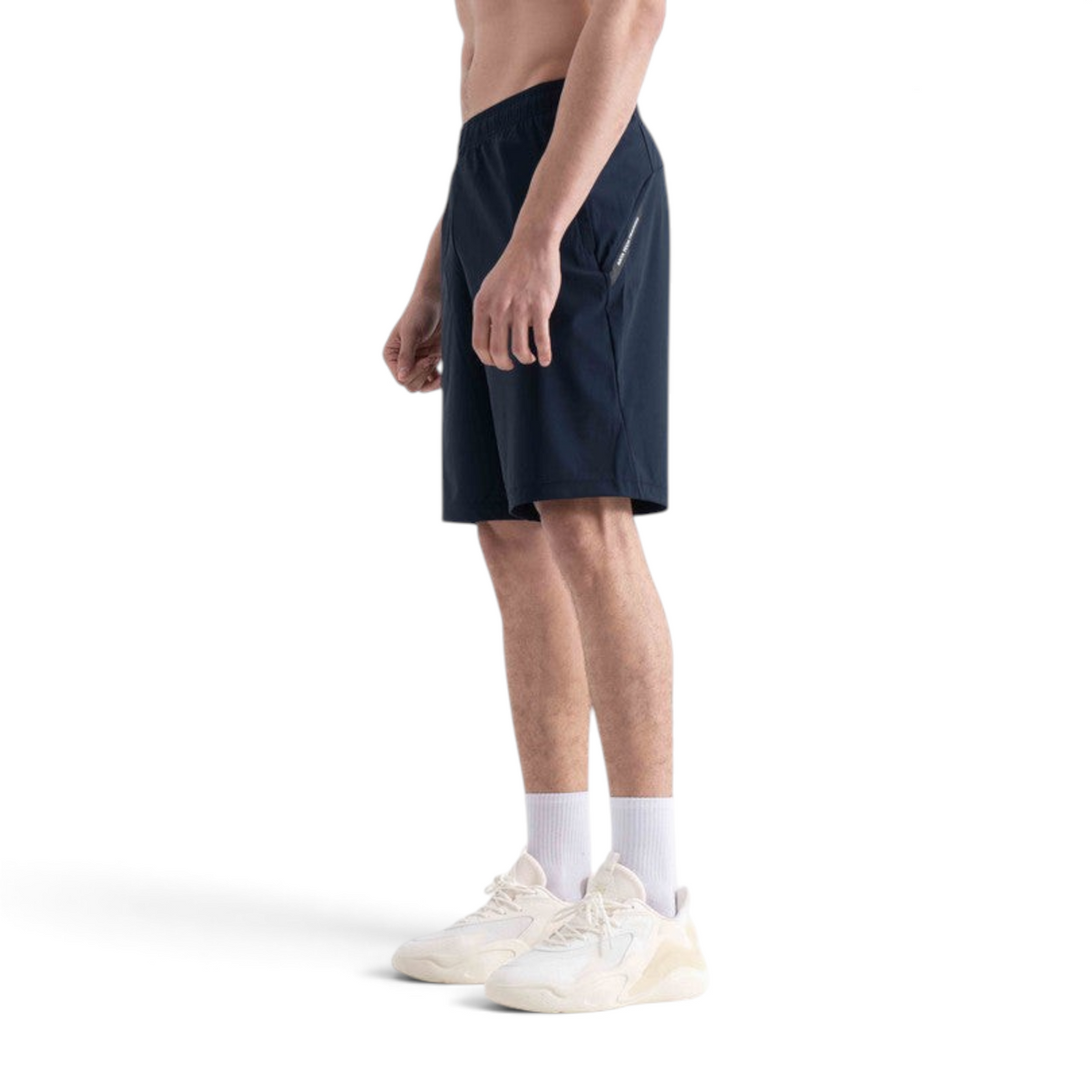 FRG knit half pants in navy blue worn by a man with white sneakers, side profile view