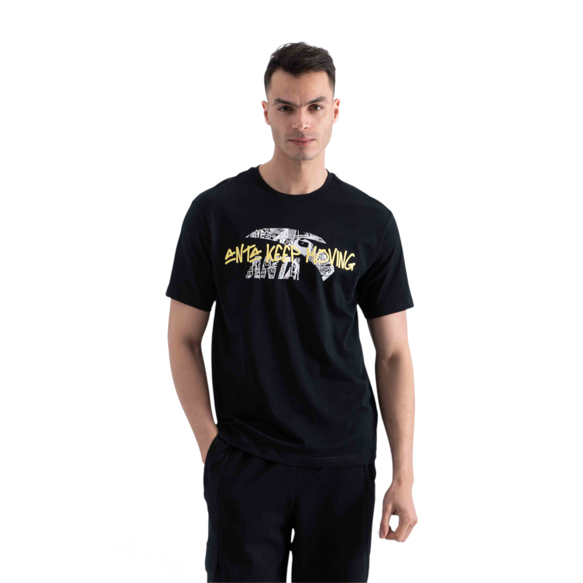 A man wearing a black FRG SS TEE with a graphic print featuring the text ANTA KEEP MOVING in yellow and white.