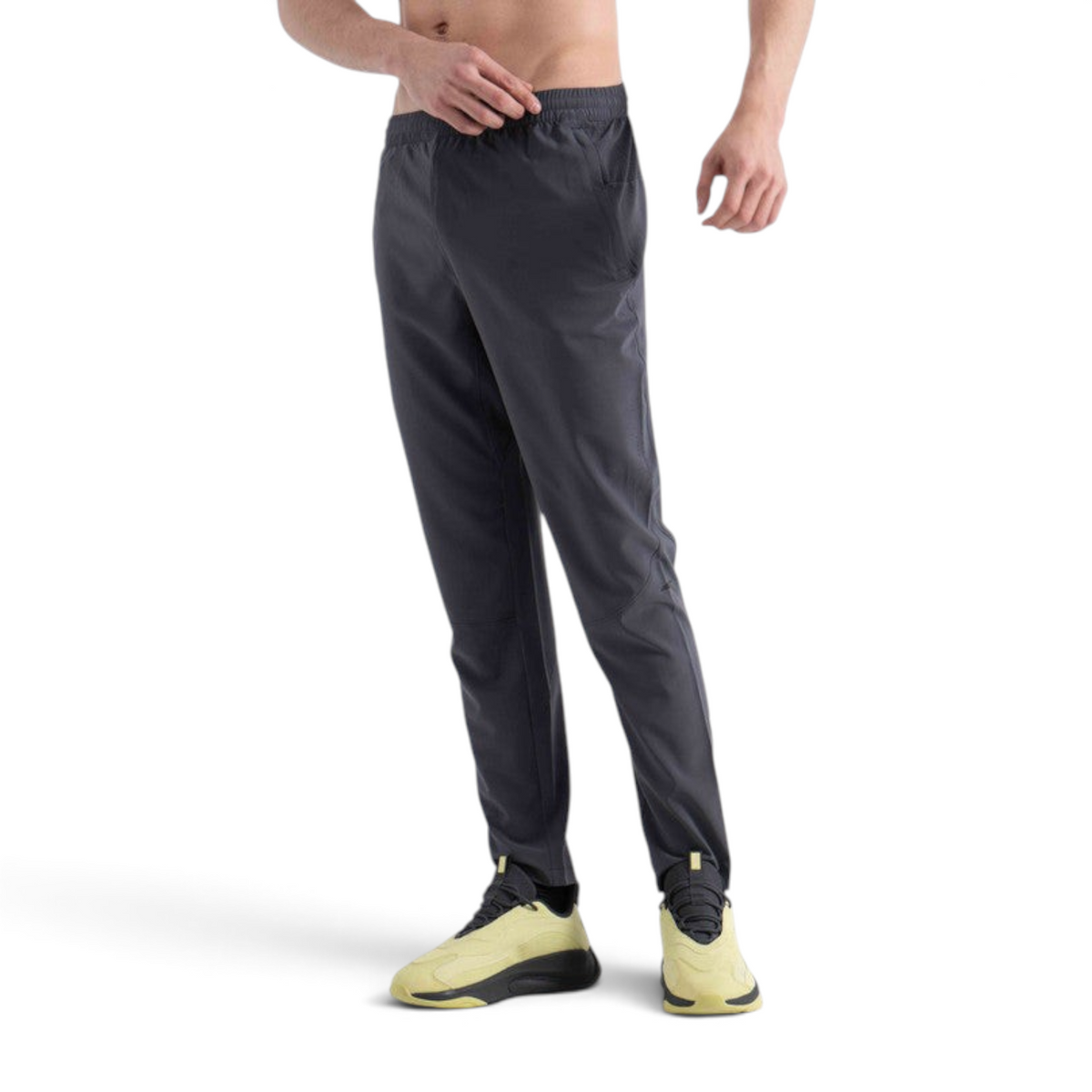 FRG men's charcoal grey woven running track pants with an elastic waistband, worn by a model with yellow sneakers.