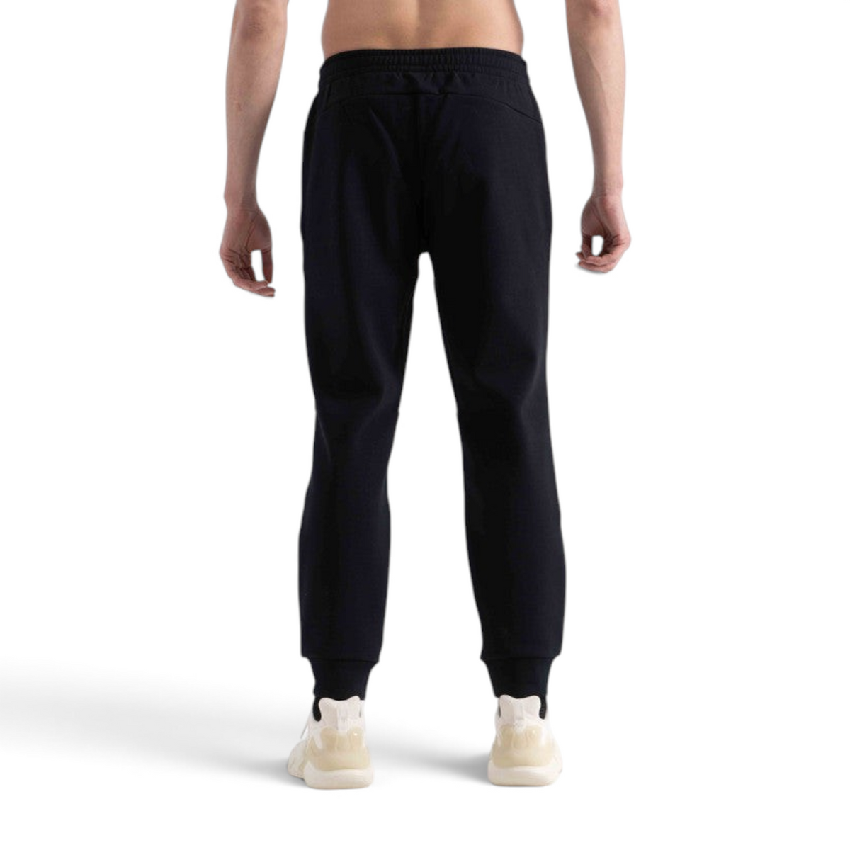Back view of a man wearing black FRG knit track pants with a comfortable elastic waistband and cuffed ankles.