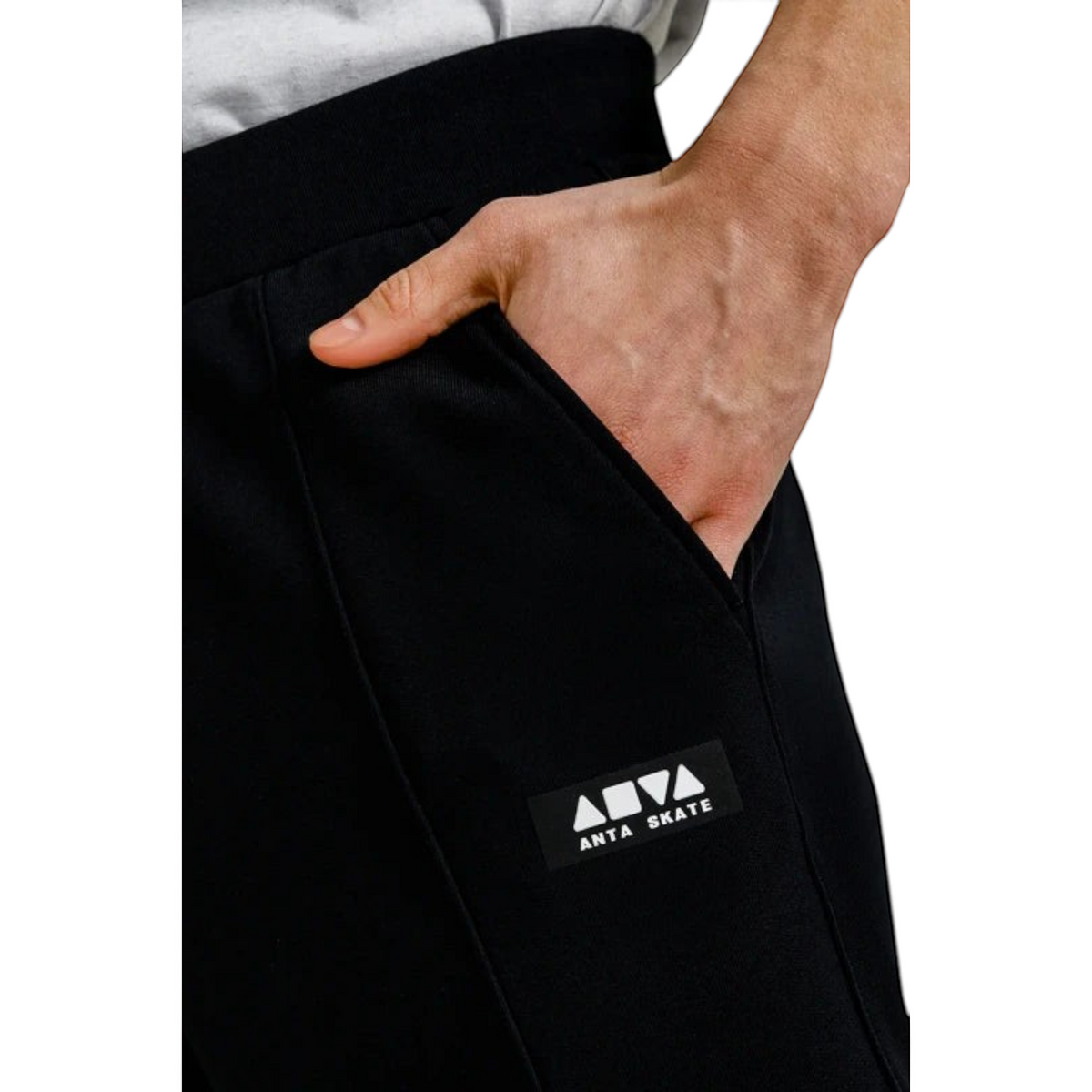 FRG ANTA black knit track pants featuring a side pocket and ANTA SKATE logo patch on a cotton-polyester blend fabric.