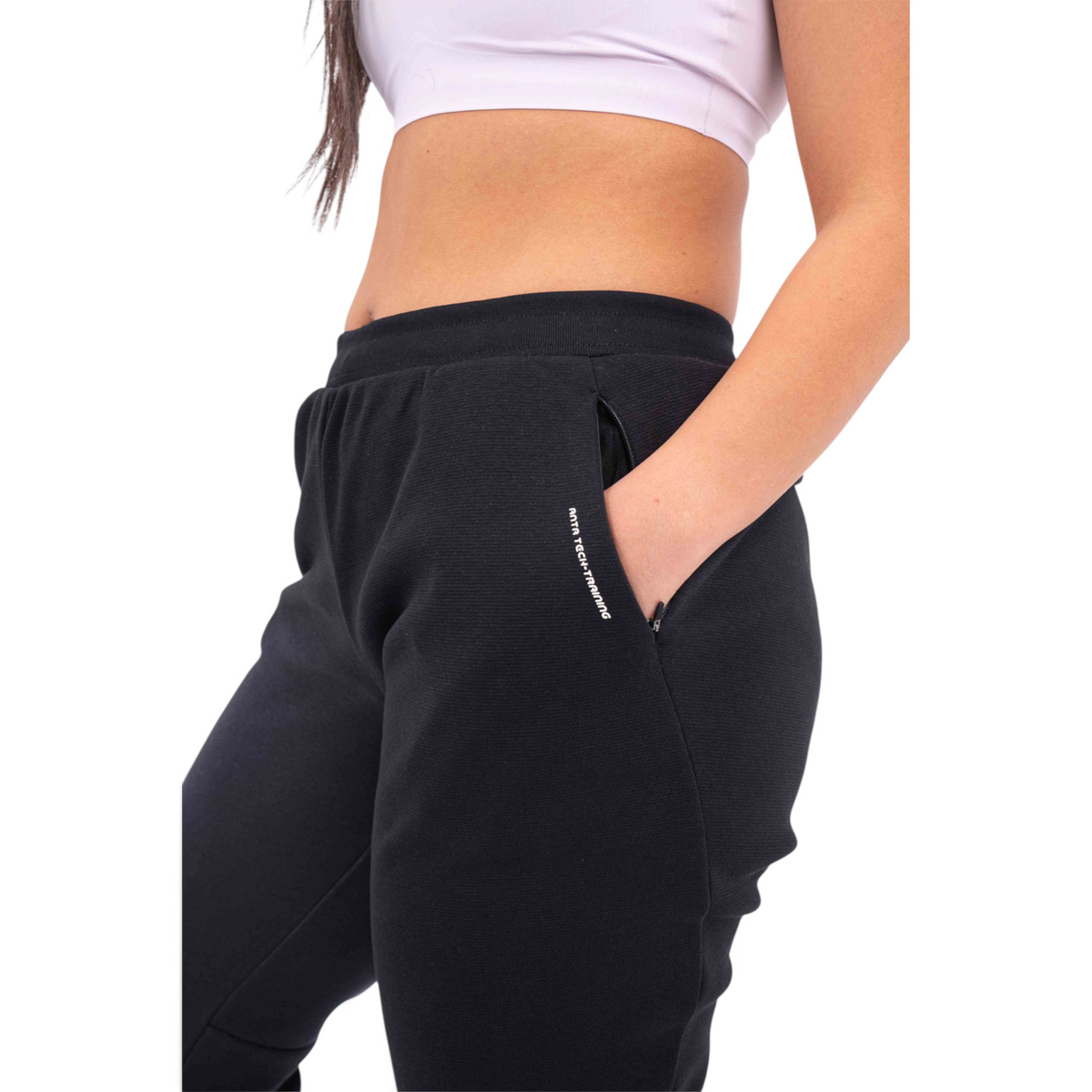 FRG knit track pants in black with a regular fit, featuring a zippered side pocket and tech training branding.