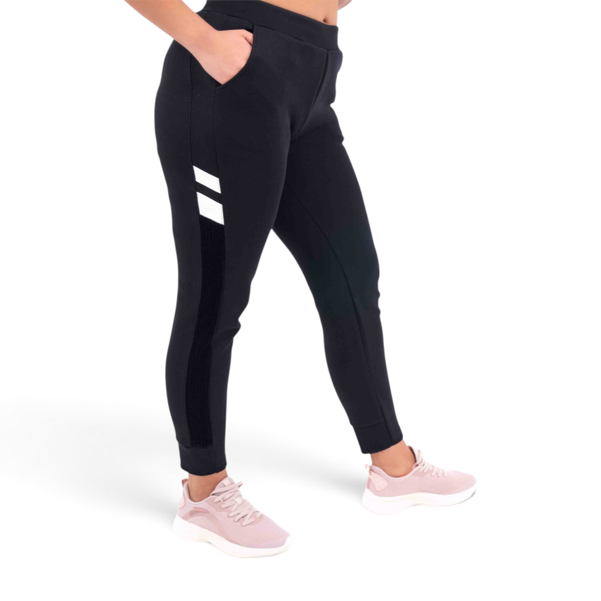 FRG black knit track pants with white side stripe detail and regular fit, worn with light pink sneakers