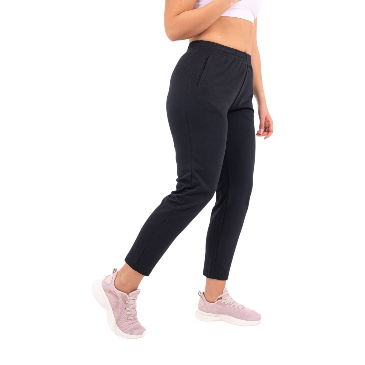 FRG black knit track pants with an elastic waistband and side pockets worn by a woman with light pink sneakers