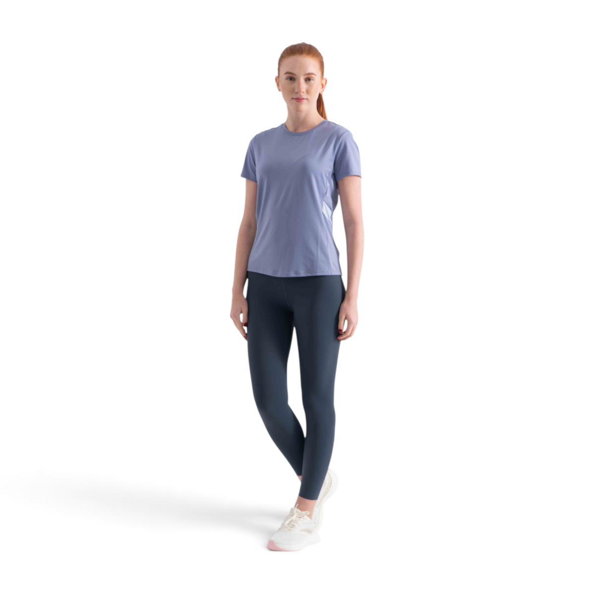 FRG SS TEE in light blue worn by a woman with dark leggings and white sneakers against a white background
