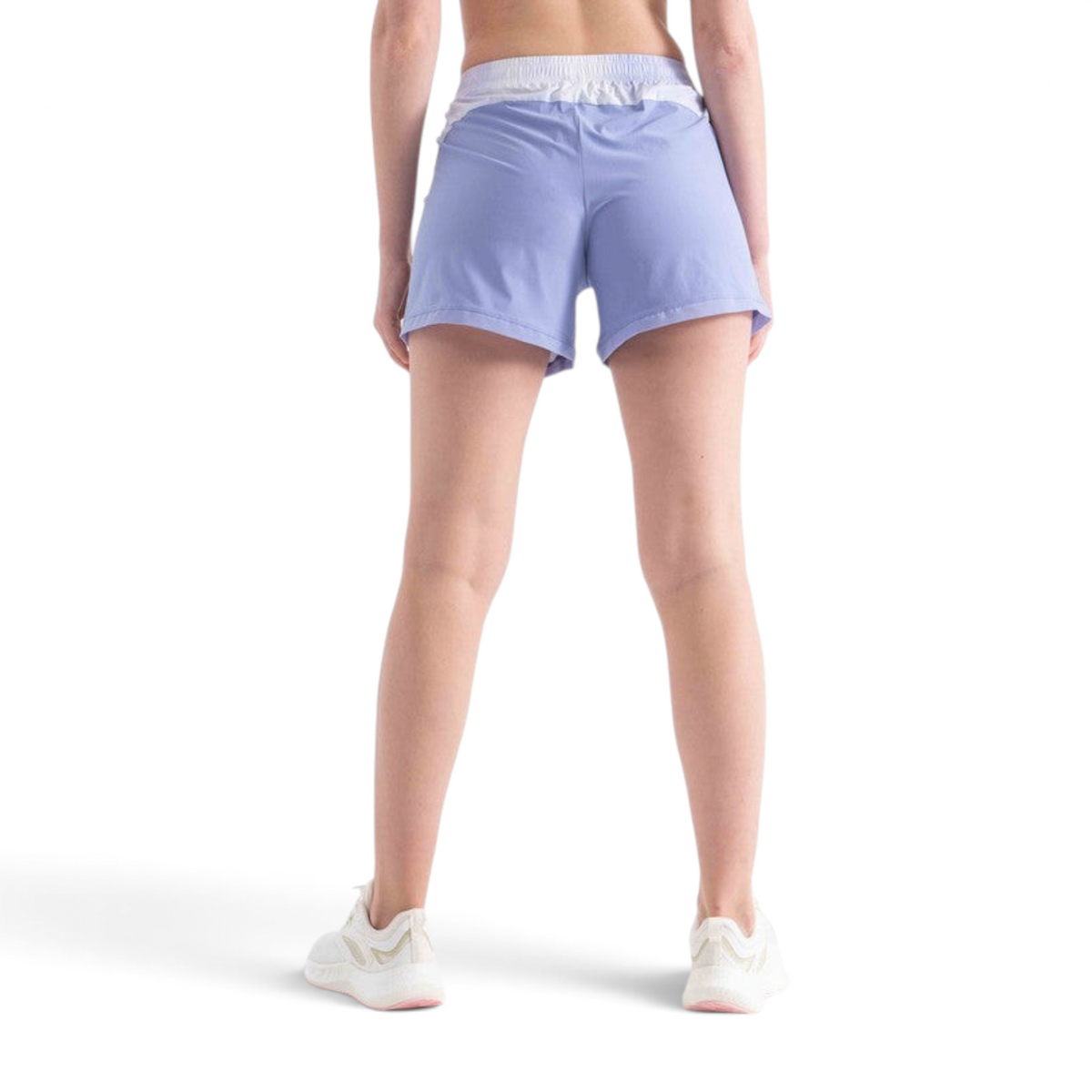 Back view of a woman wearing FRG light purple athletic shorts with a white waistband on a white background