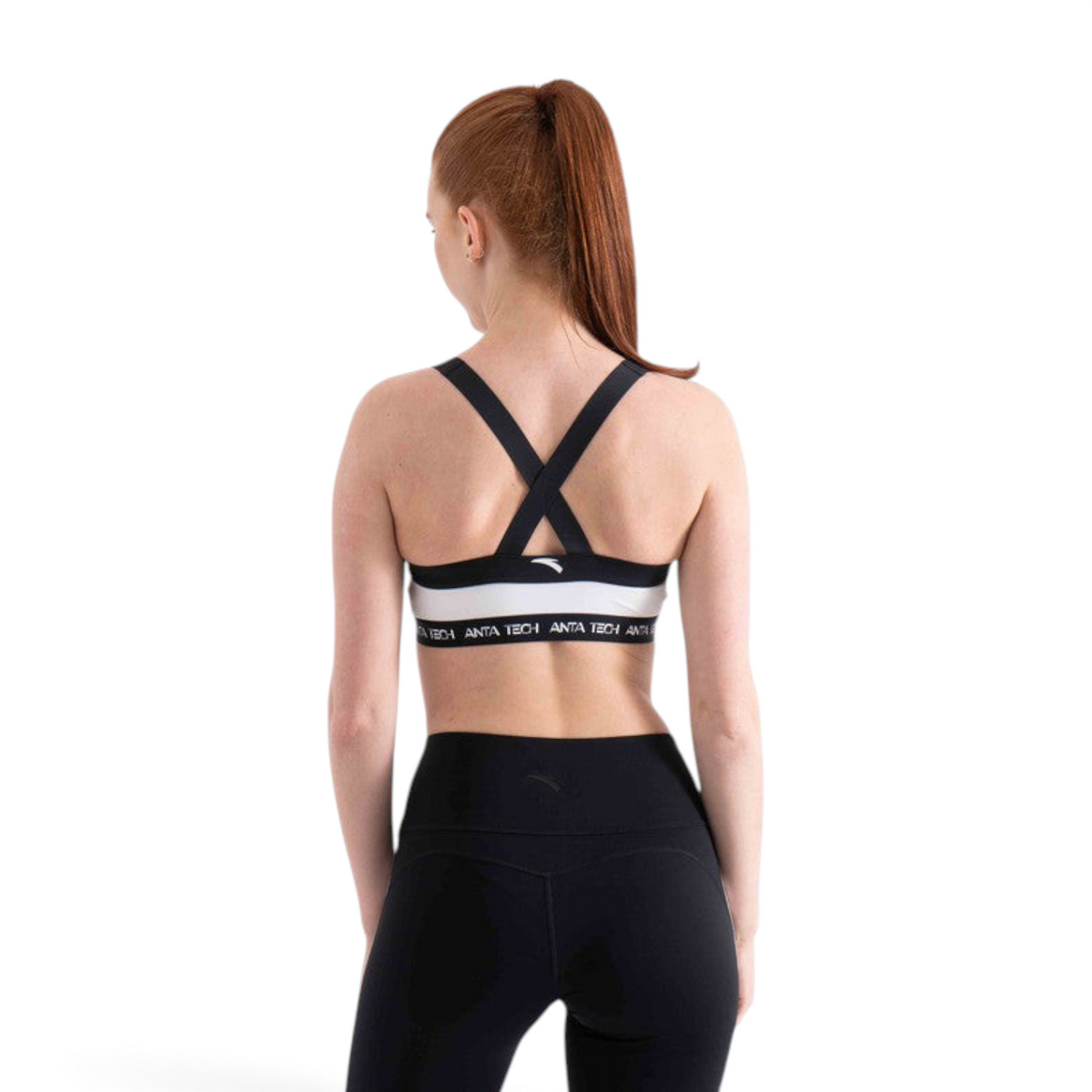 FRG sports bra with black and white color block design and crisscross back straps worn by a woman
