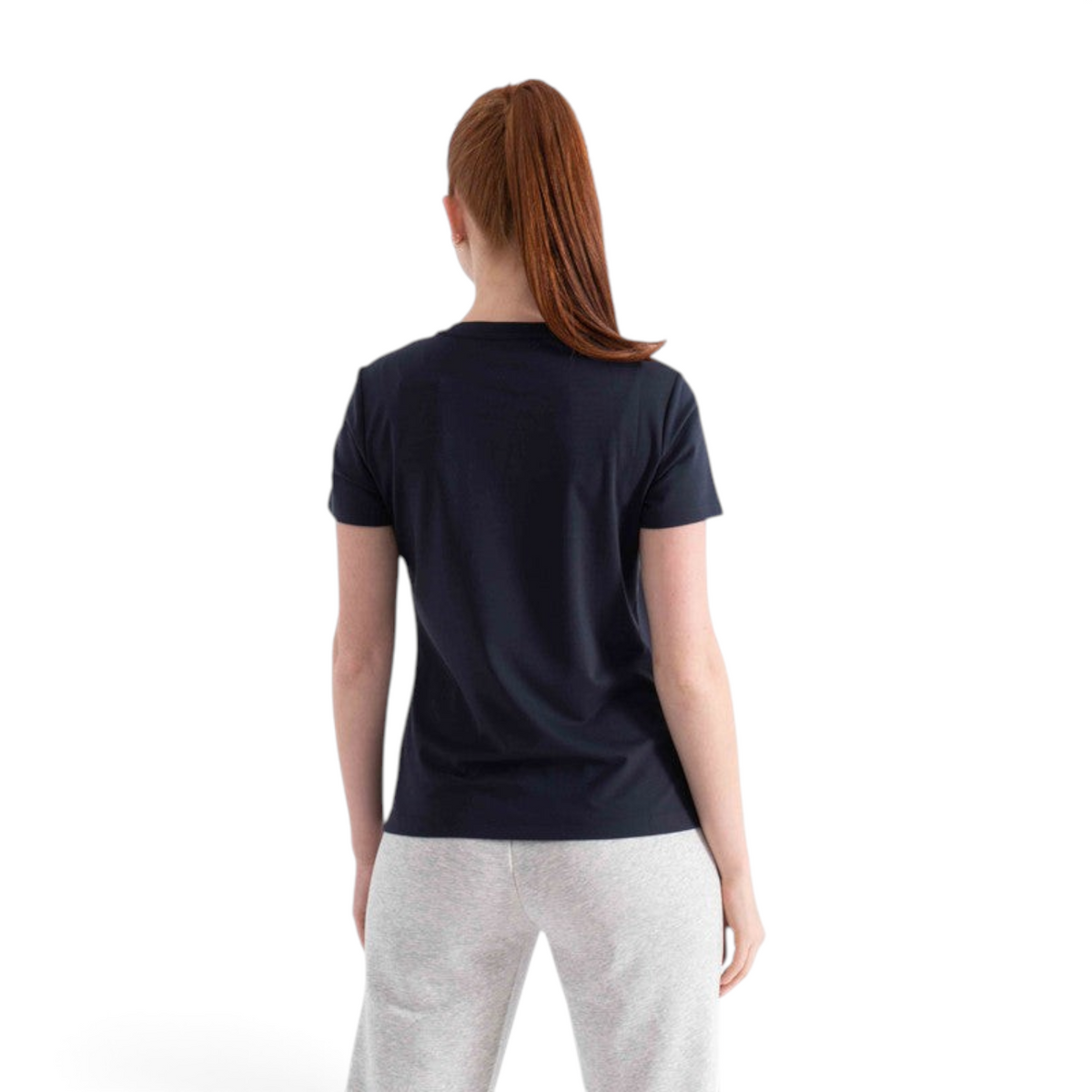 Back view of a woman wearing a plain navy blue FRG short sleeve cotton t-shirt with grey lounge pants