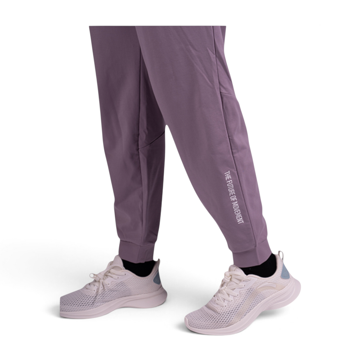 FRG knit ankle pants in dusty purple featuring a cuffed hem and white text detail, worn with white athletic sneakers.
