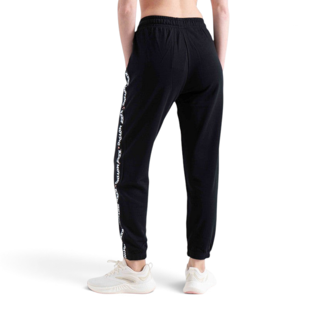 FRG black knit track pants with white side stripe featuring Keep Moving text, worn with white sneakers