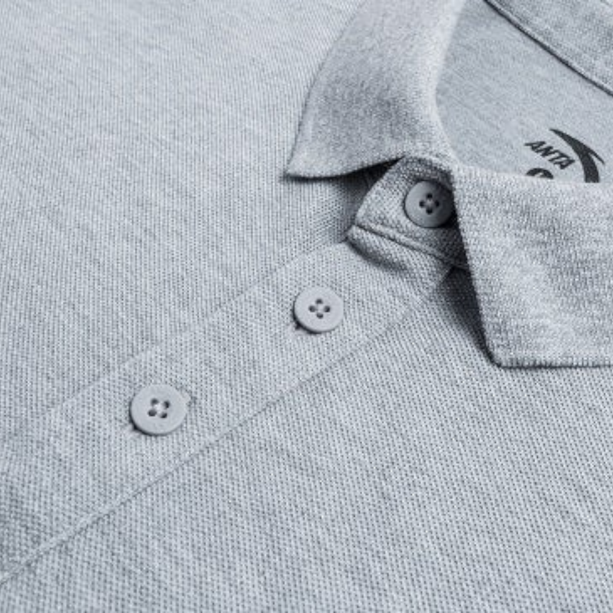 Close-up of a grey FRG SS POLO shirt featuring a classic collar, button placket, and textured pique fabric.