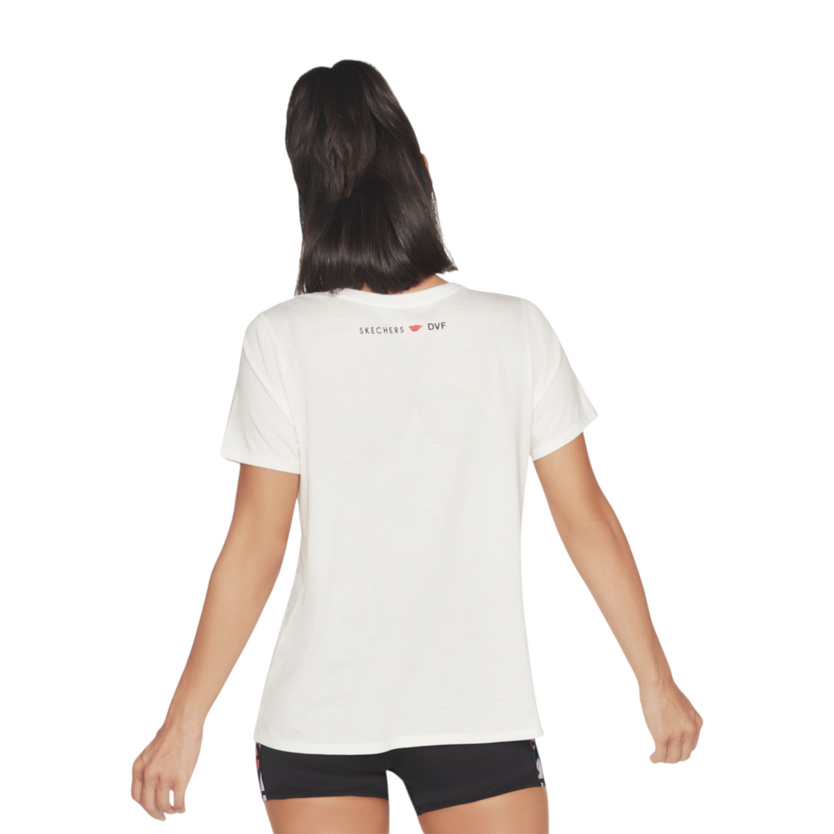 Back view of a woman wearing a white FRG DVF Godri tee with a small Skechers DVF logo on the upper back
