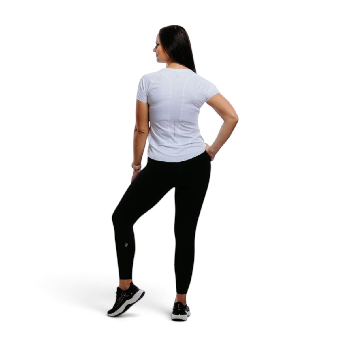 FRG model wearing ANTA black yoga crop tights and a white t-shirt, viewed from the back in a studio setting