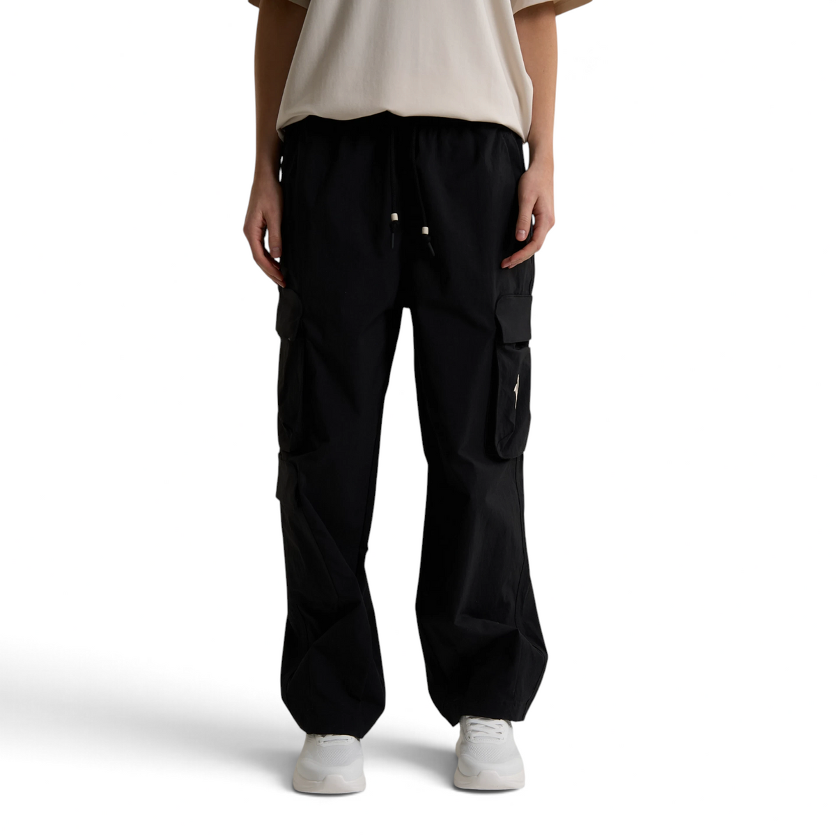 FRG ANTA black woven cargo pants with side pockets and drawstring waist worn by a model in a studio setting