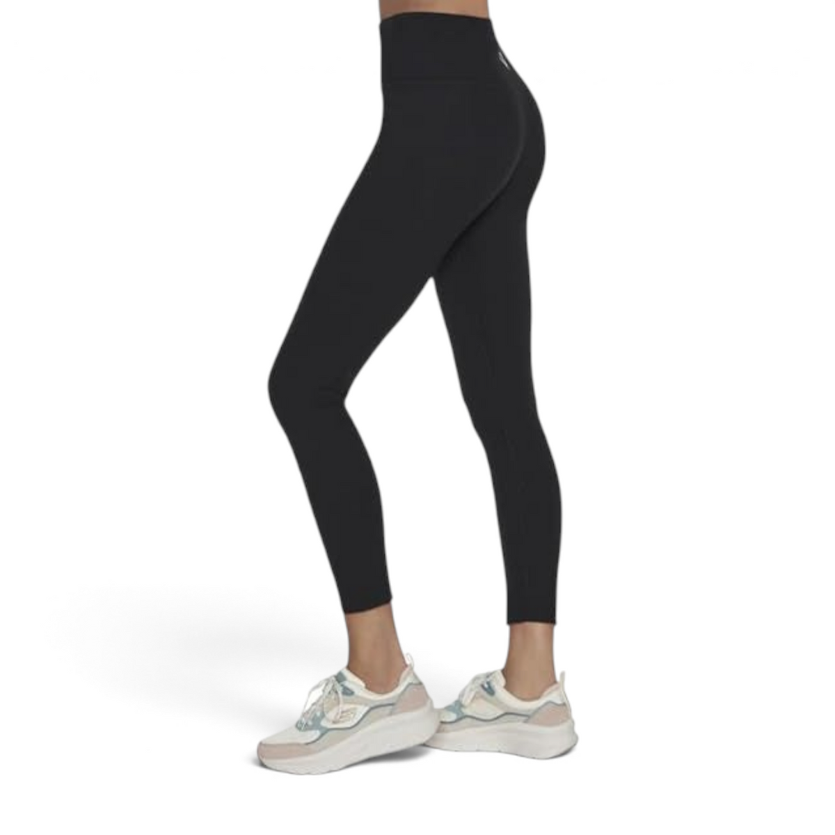 FRG black high-waisted leggings with a scalloped hem detail worn with white athletic sneakers, side view