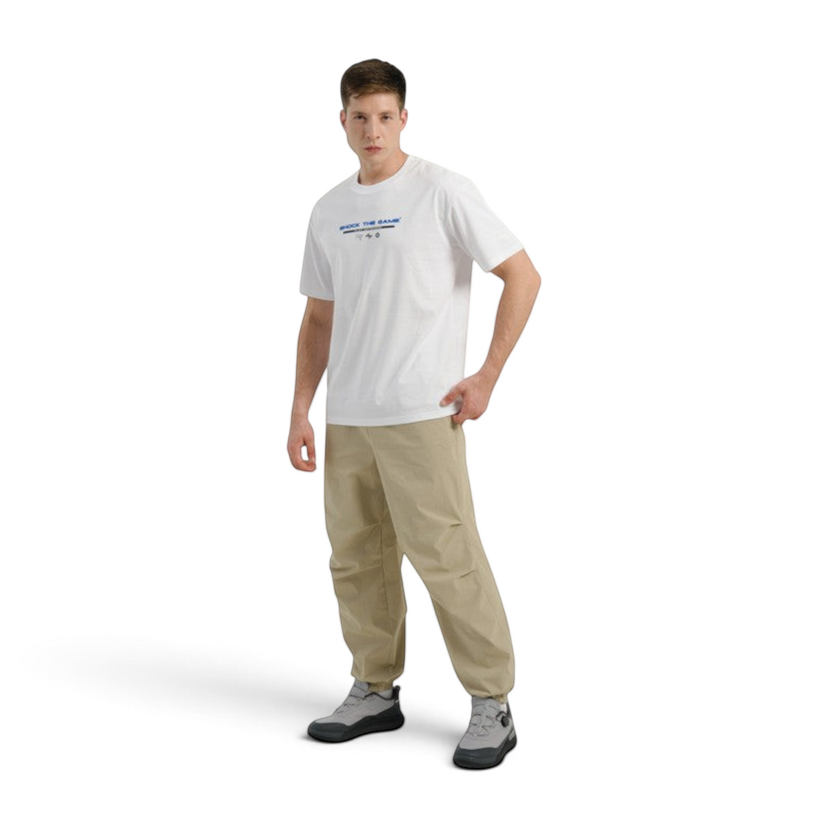 FRG COMMUTE relaxed woven track pants in beige worn by a male model with a white graphic t-shirt and grey sneakers