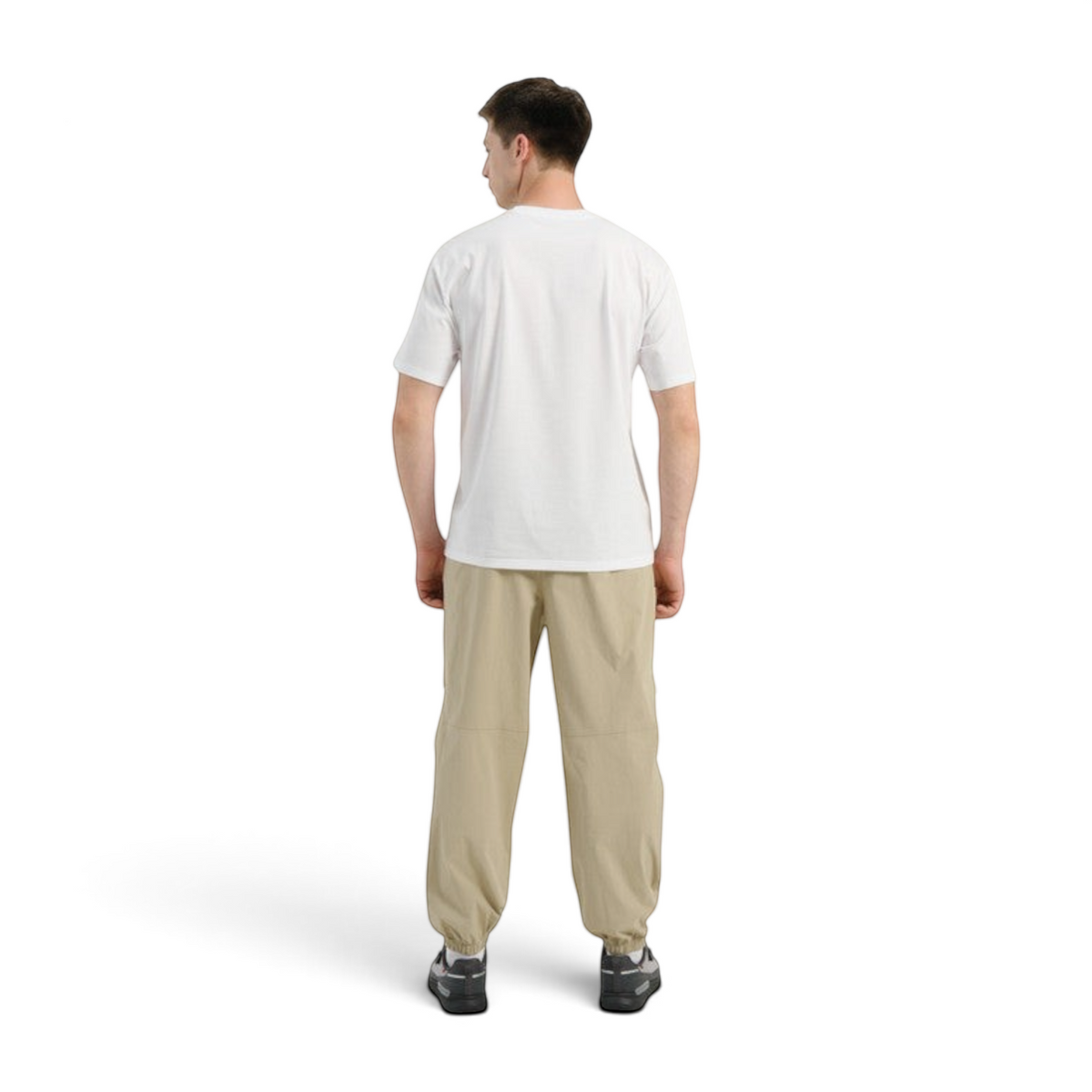 Back view of a man wearing FRG COMMUTE relaxed beige woven track pants with elastic cuffs and a white t-shirt