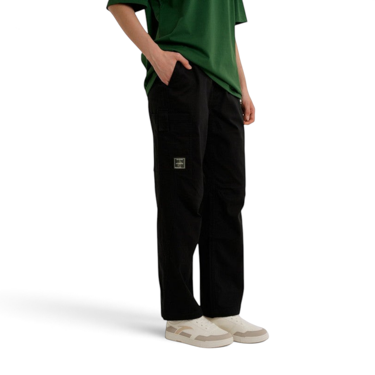 FRG ANTA SKATE black woven casual pants with a relaxed fit and side pocket detail worn with a green t-shirt