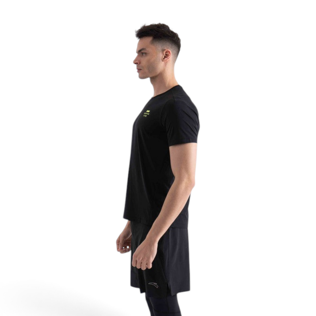 FRG black short sleeve t-shirt with a small yellow chest logo worn by a man in profile view
