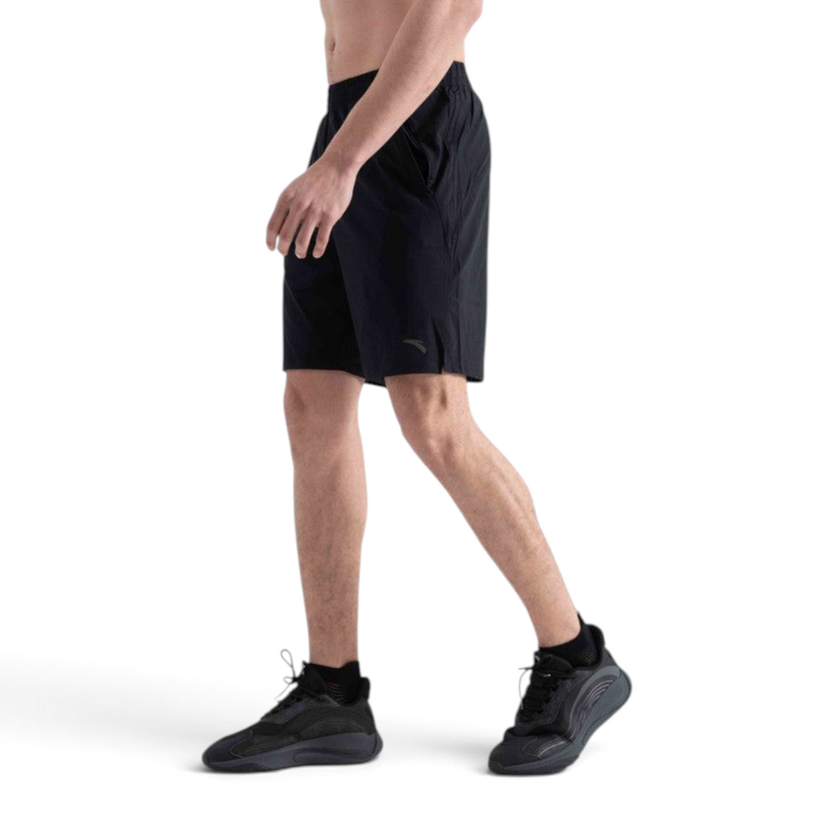 A model wearing black FRG athletic shorts, side view, featuring a lightweight performance fabric for sports.