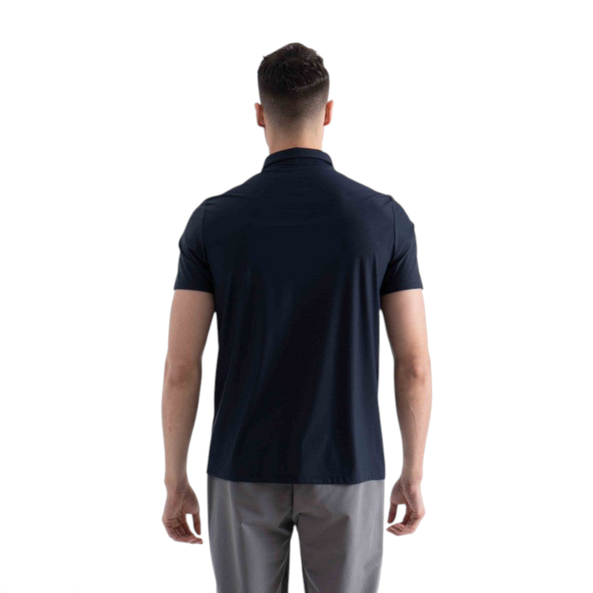 Back view of a man wearing a navy blue FRG short sleeve polo shirt with grey trousers against a white background.