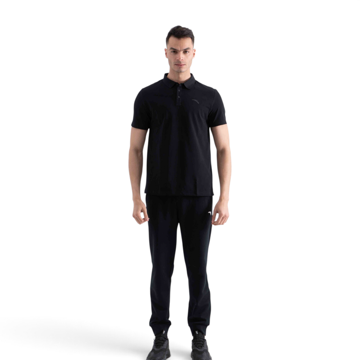 FRG model wearing a black short-sleeve polo shirt and matching black athletic trousers against a white background.