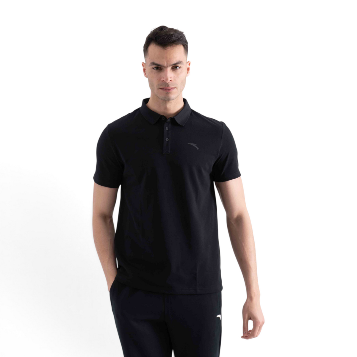 A man wearing a black FRG short-sleeve polo shirt with a classic collar and button placket against a white background