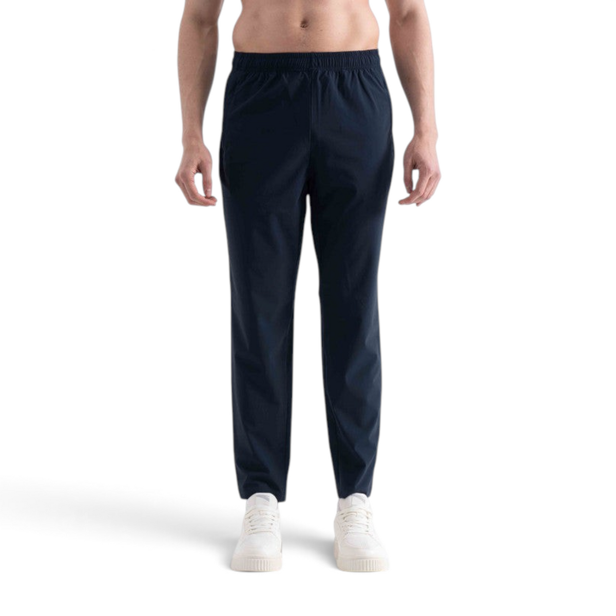 A man wearing navy blue FRG knit track pants with an elastic waistband, styled with white sneakers.