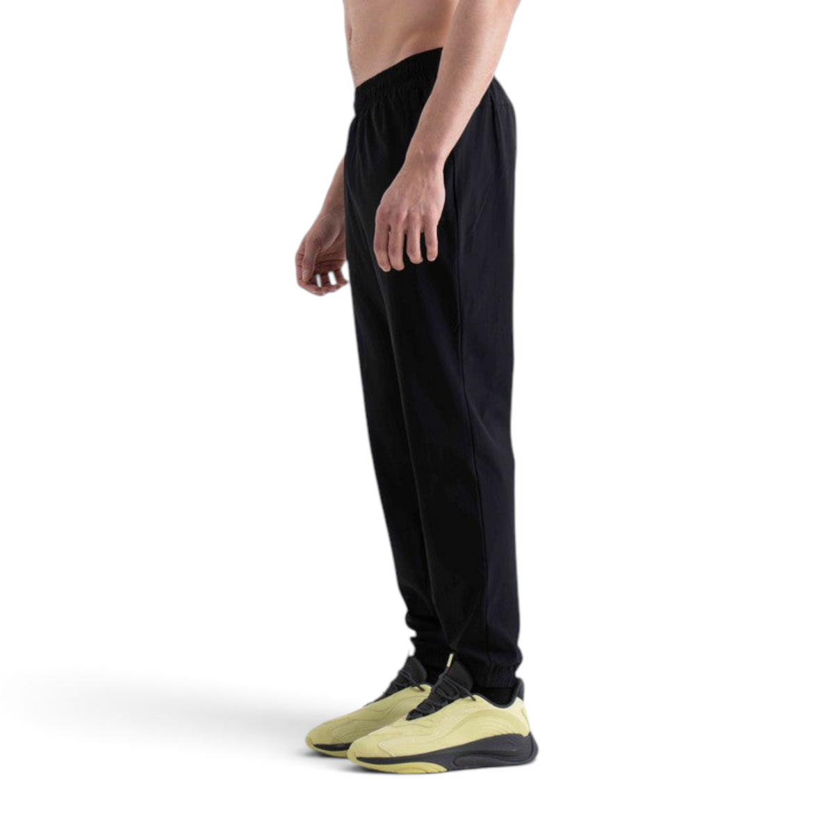 FRG black knit track pants with an elastic waistband worn by a model in a side profile view