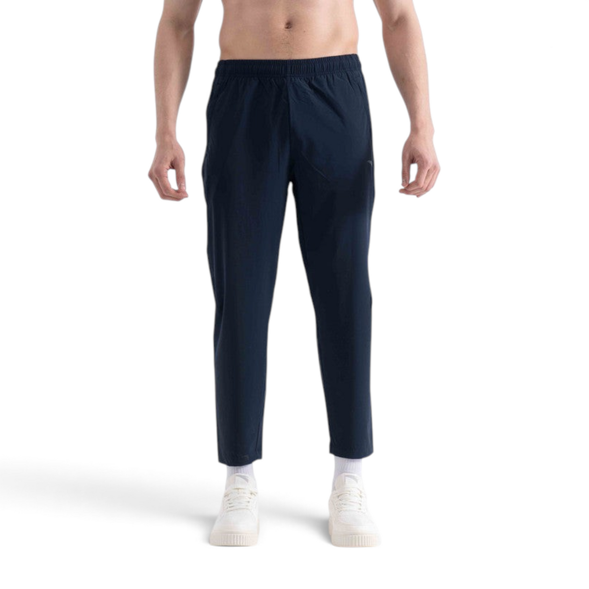 FRG ankle pants in navy blue worn by a man with white sneakers against a plain white background