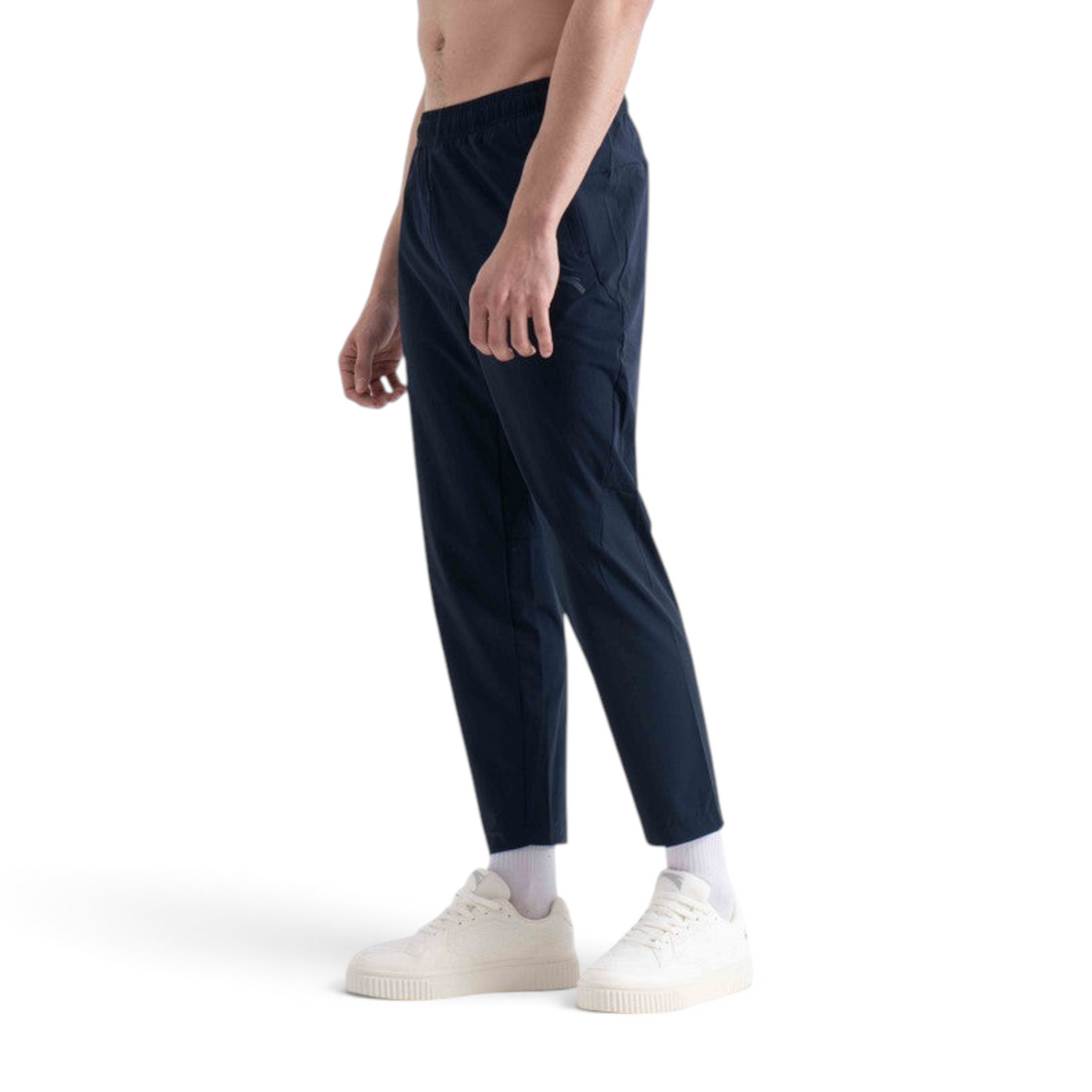 FRG navy blue ankle pants worn by a man with white sneakers against a plain white background