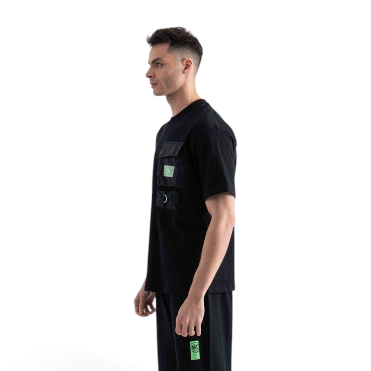 FRG black short sleeve t-shirt with utility cargo pockets and neon green accents worn by a man in profile view