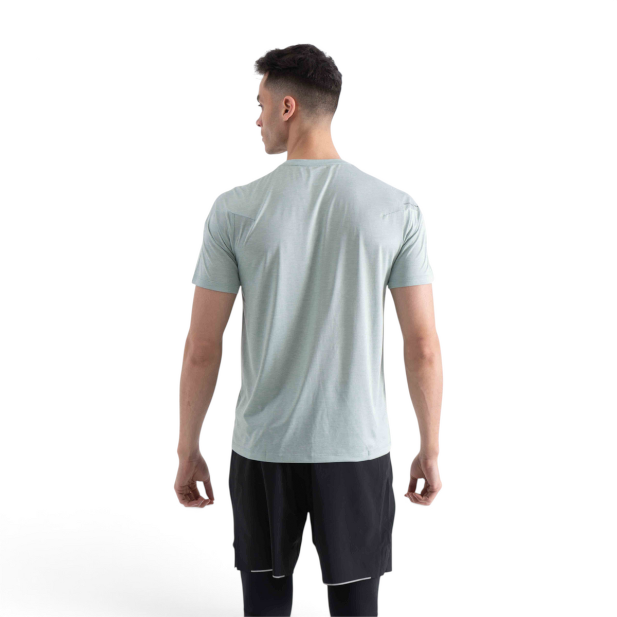 A man wearing a light green FRG SS TEE short-sleeve shirt, viewed from the back against a plain white background.
