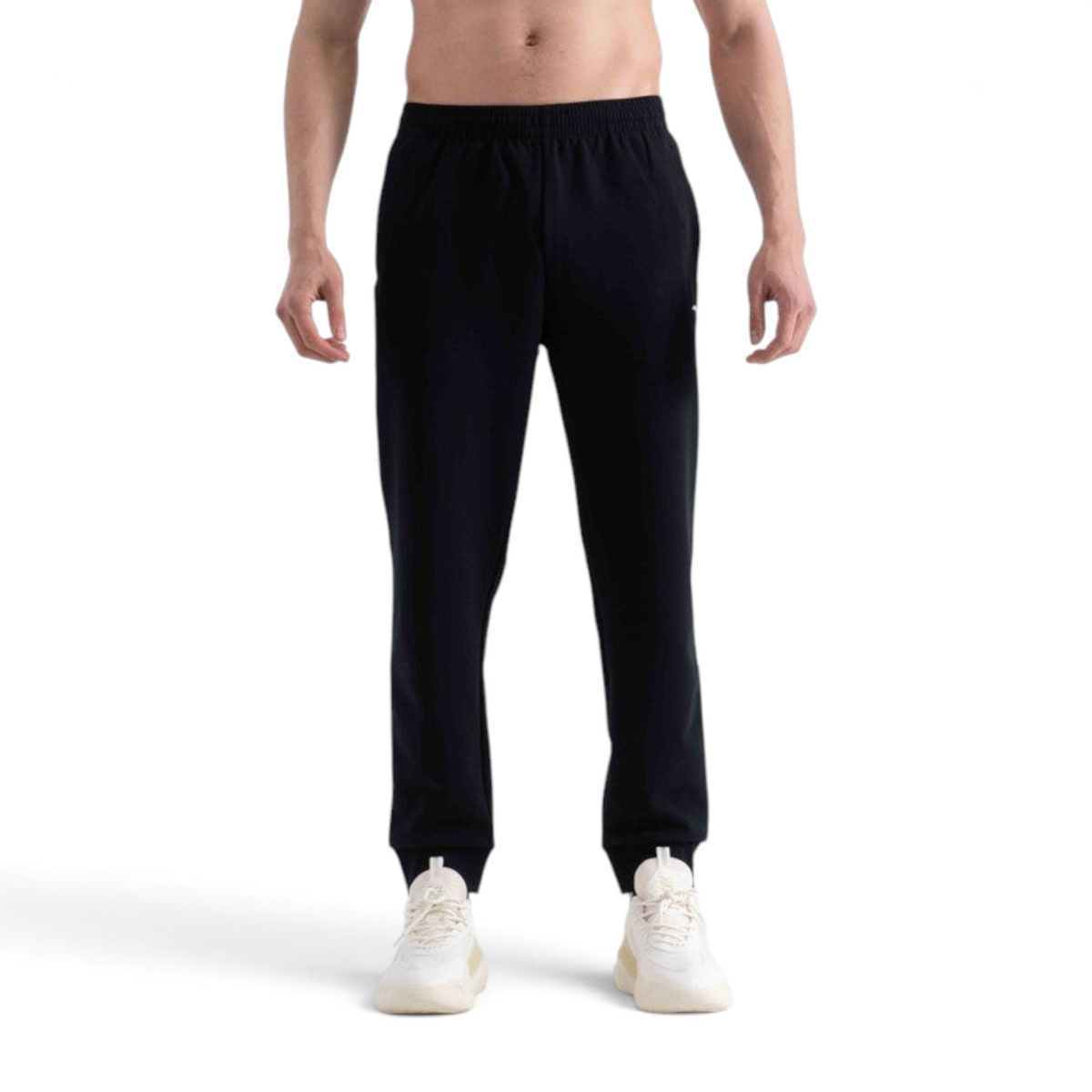 FRG black knit track pants with an elastic waistband and cuffed ankles worn by a man with white sneakers