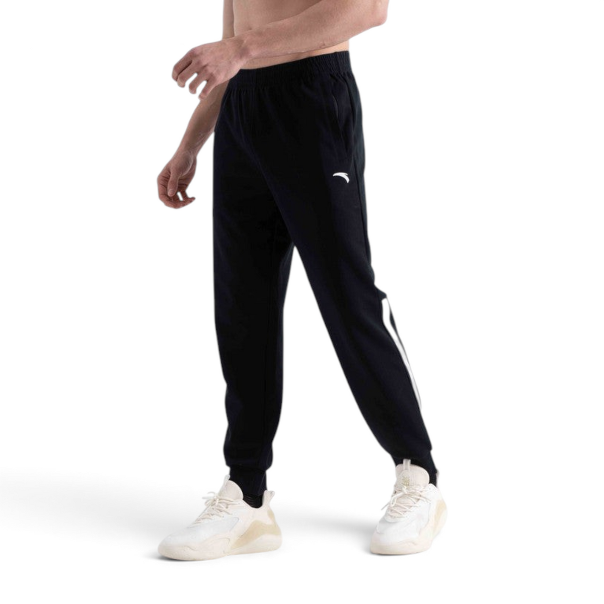 FRG knit track pants in black with white side stripe detail worn by a man with white sneakers