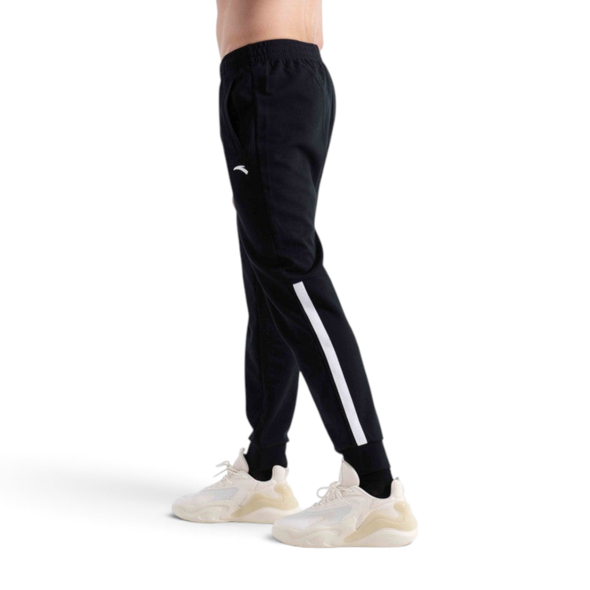 FRG black knit track pants with a white side stripe detail worn by a model with white sneakers