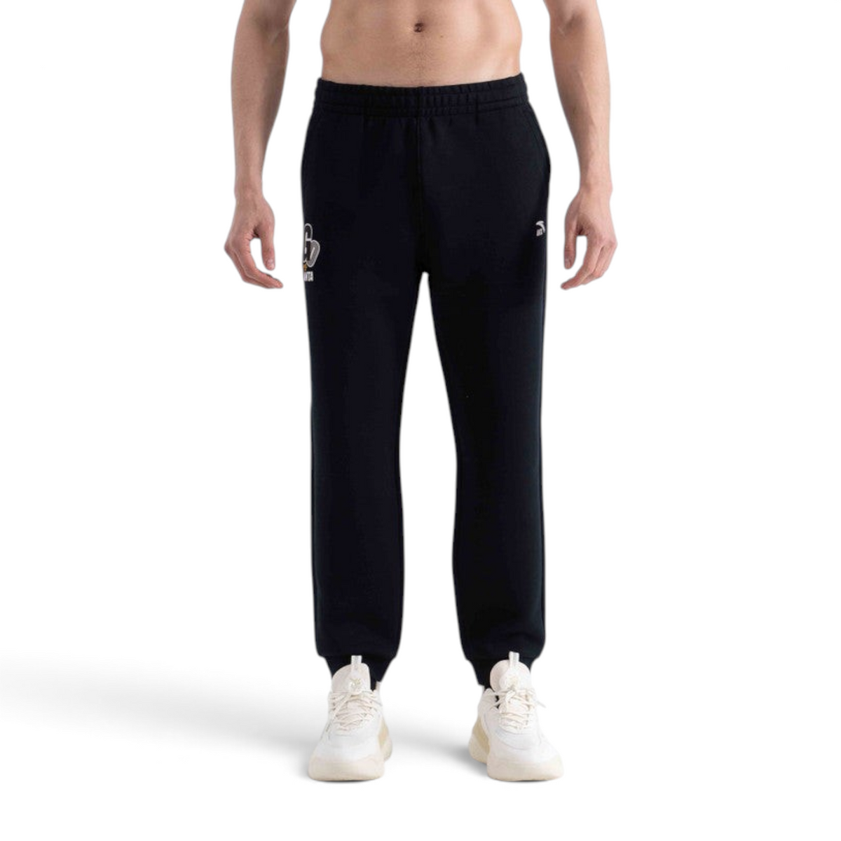 FRG knit track pants in black with a small logo detail, worn by a man with white sneakers