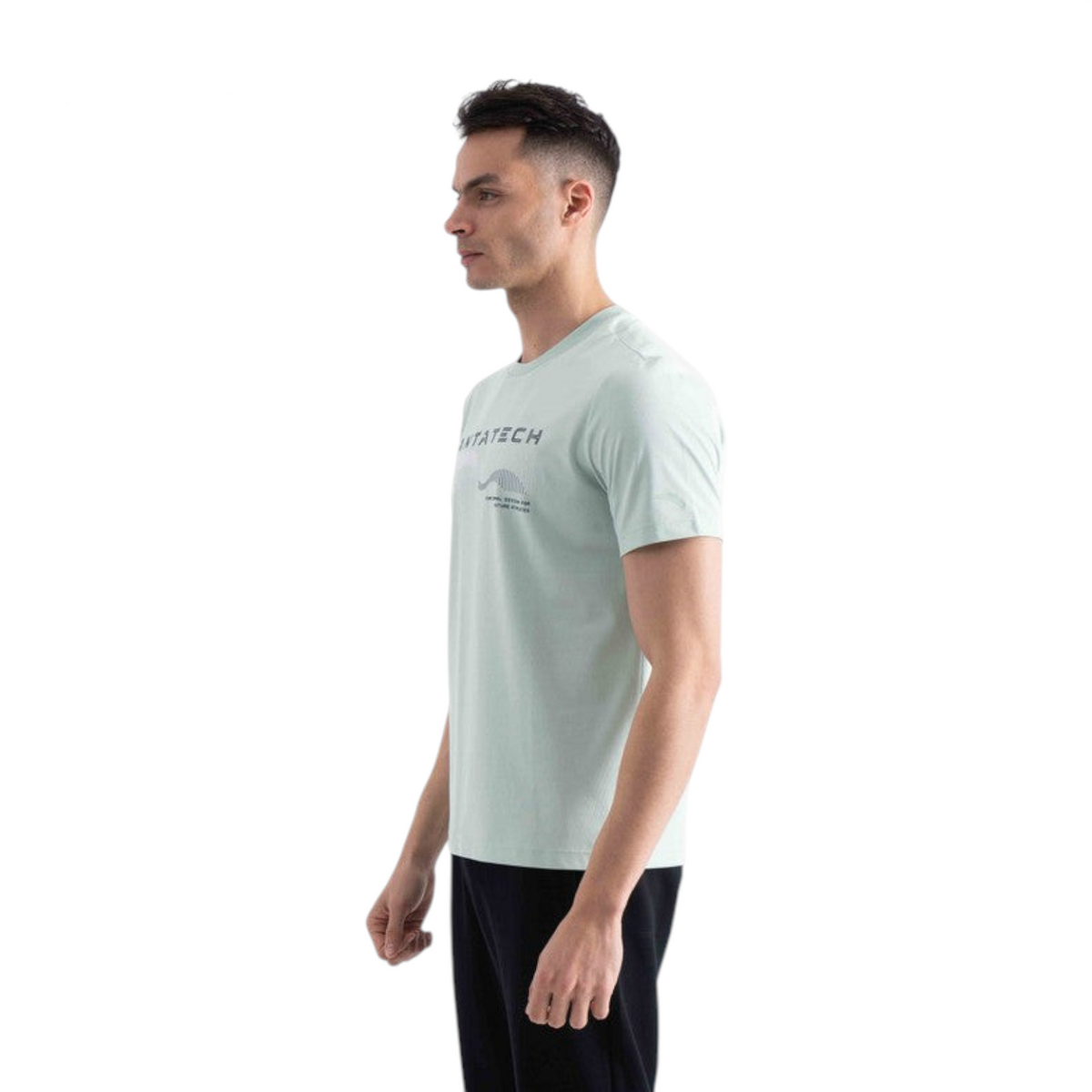 A man wearing a light green FRG SS TEE with a graphic print on the chest, viewed from the side.