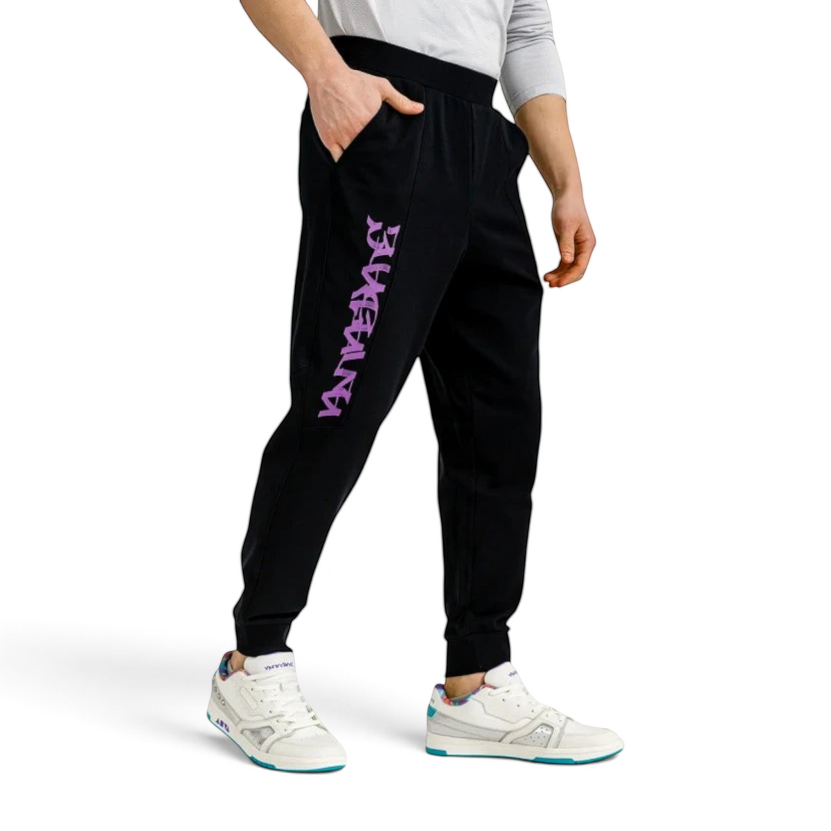 FRG ANTA black knit track pants with purple graphic logo on the leg, worn by a man with white sneakers.