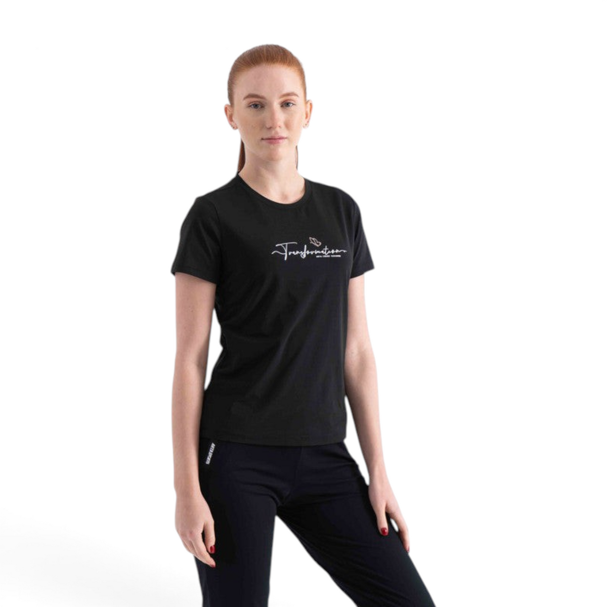 A woman wearing a black regular fit FRG polyester t-shirt with a white Transformation graphic on the chest.