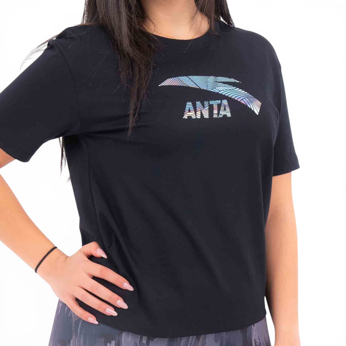 FRG black cotton t-shirt featuring a holographic ANTA logo graphic on the chest worn by a woman