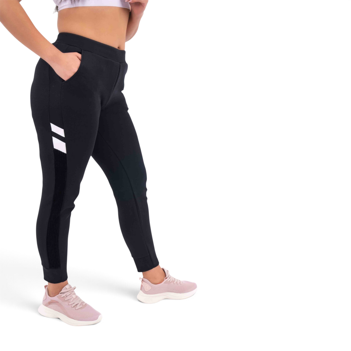 FRG black knit track pants with white side stripes and pockets worn by a model with pink sneakers