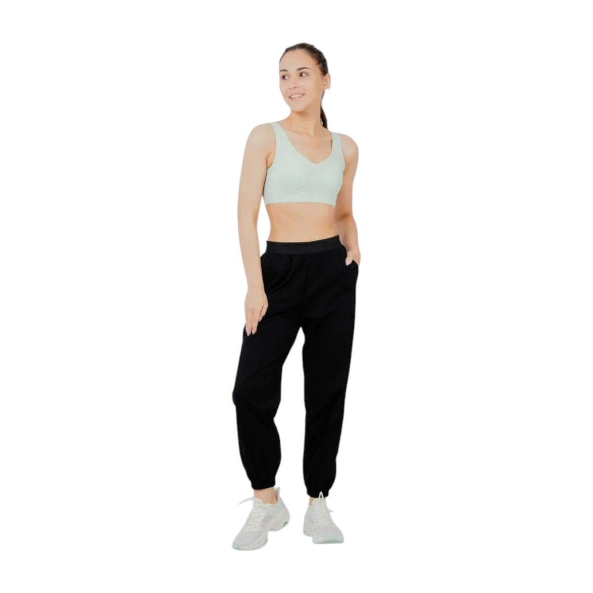 FRG ANTA knit track pants in basic black worn by a woman with a light green sports bra and white sneakers