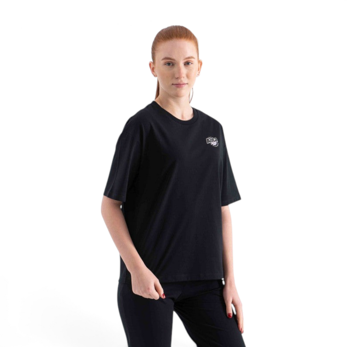 A woman wearing a black FRG short-sleeve crew neck t-shirt with a small white graphic logo on the chest.