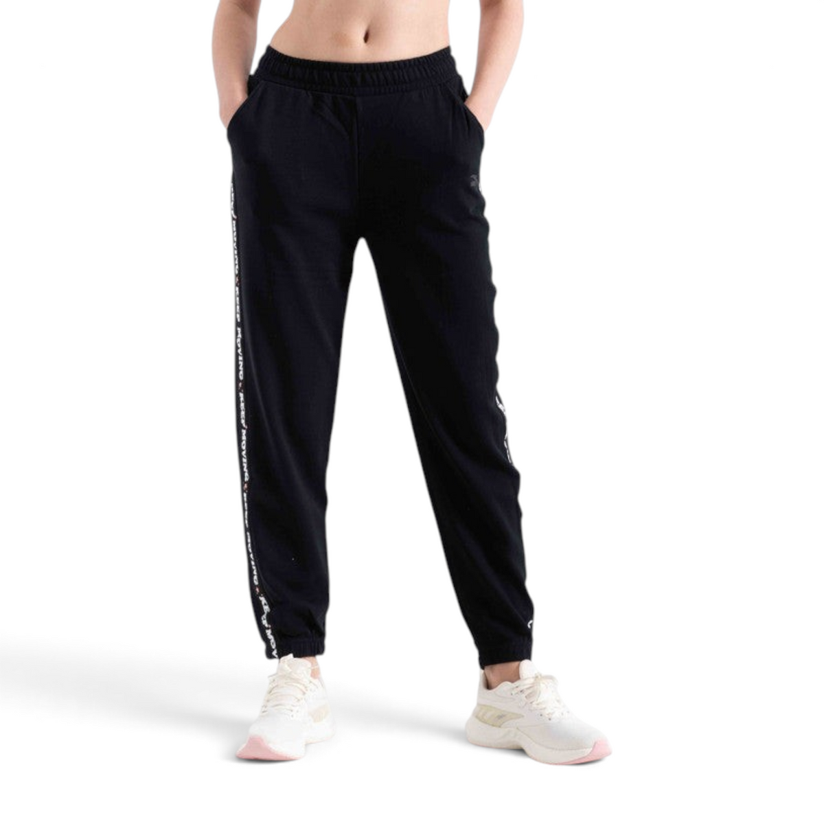 FRG black knit track pants featuring a white side stripe with text detail, worn by a model with white sneakers.