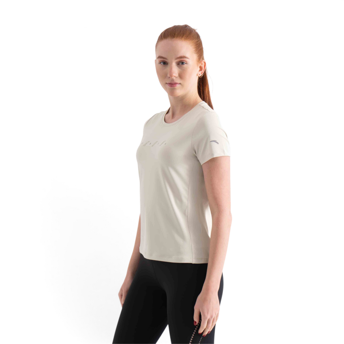 FRG SS TEE in beige worn by a woman with red hair, featuring a crew neck and short sleeves for athletic wear.